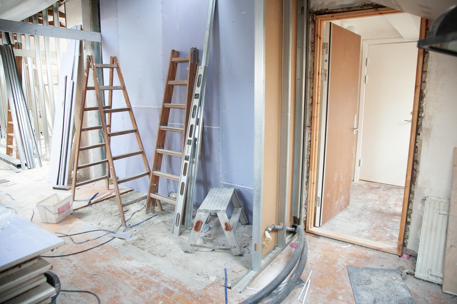 Interior with metal stud framing and blue plasterboard walls going up