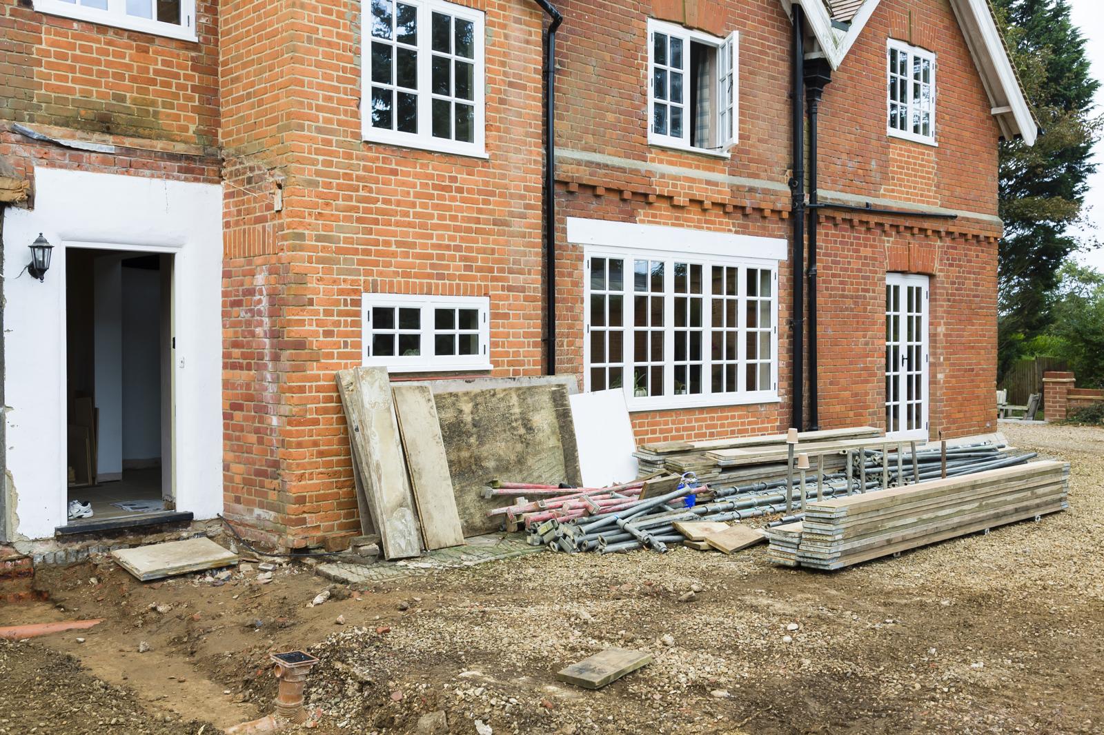 Brick house with new white window frames installed during renovation